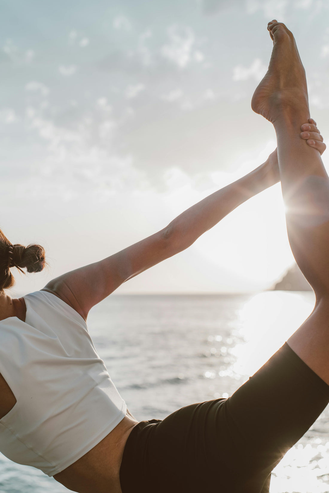 Unlock Vital Energy and Longevity with NAD Plus Wellness Supplements - a woman practicing yoga by the ocean.